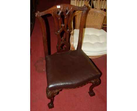 A set of four Chippendale style low relief carved mahogany dining chairs, each having chocolate brown leather stuffover seats