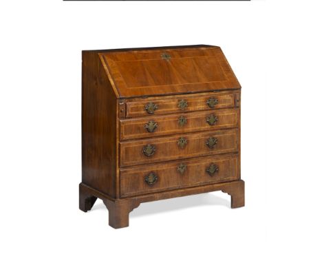 GEORGE II WALNUT BUREAU18TH CENTURY the crossbanded slant front opening to an interior fitted with pigeon holes, drawers, and