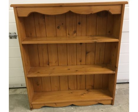A small pine 3 shelf bookcase with shaped detail to top and bottom.  Approx.84cm wide x 93cm tall x 18cm deep.