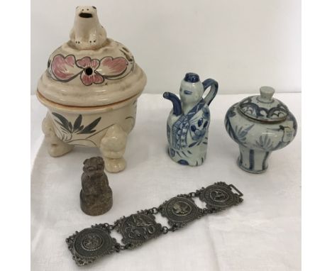 A small collection of oriental items. To include a ceramic water dropper, a natural stone Foo dog seal stamp and a white meta