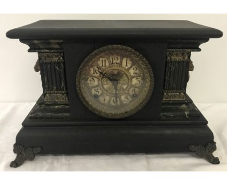 A vintage wooden cased mantel clock with decorative face and column detail to sides.  Approx. 44cm wide x 27.5cm tall.