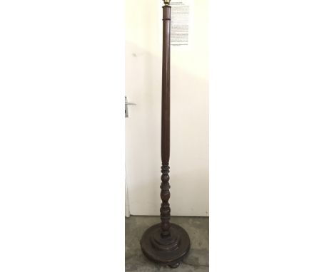 A vintage dark wood standard lamp with turned pedestal.  