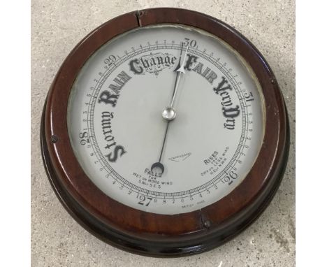 A dark oak surround vintage wall barometer.  Approx. 22cm dia.