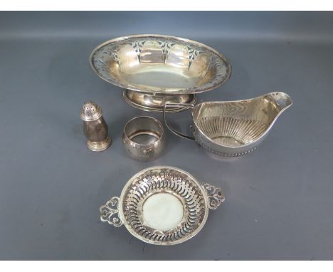 Five items of hallmarked silver including a milk jug of embossed rib design, a pepper, a pin tray, napkin ring and sweet meat