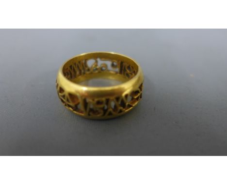 A 9ct yellow gold ring with pierced decoration to centre - approx weight 8.6 grams - tested as better than 9ct - surface scra