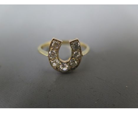 An 18ct yellow gold and diamond ring - the seven diamonds graduating from approx 0.25ct to 0.06ct - in a horseshoe setting - 