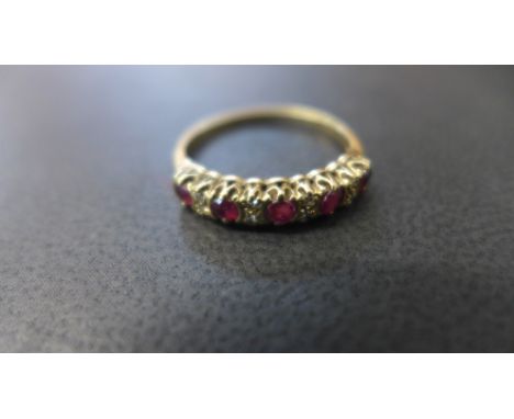 A 9ct yellow gold dress ring with five rubies and eight small diamonds to shoulder - ring size O - approx weight 1.6 grams - 