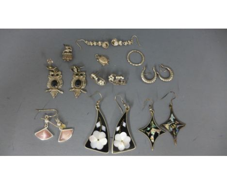 A selection of costume jewellery in the form of earrings, charms and a ring - varying condition