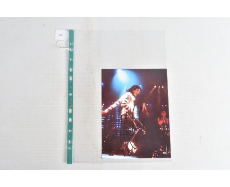 A SIGNED 6   X 8   PHOTOGRAPH OF MICHAEL JACKSON ON STAGE, signed in black marker and in its plastic sleeve, viewing is advis