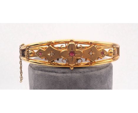 9ct gold Victorian hallmarked maker D + Co, 
9ct gold bangle set with ruby + diamond stones fitted with a safety chain, 
Appr
