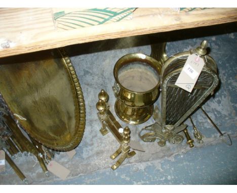 An Eastern brass plaque, a brass folding fan firescreen, brass fire dogs, brass jardinere with lion mask ring handles, fire i