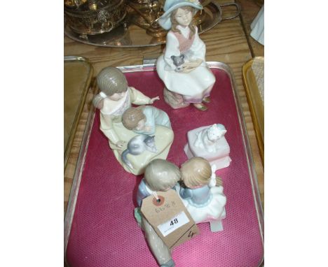 A Nao group , two children sat on a bench, a Lladro group two children with a kitten, a Lladro model of a girl sat with a pup
