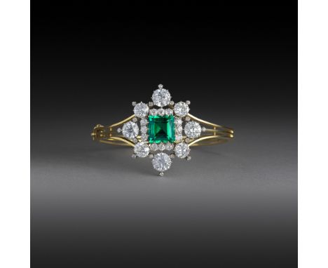 A superb Victorian emerald and diamond bangle, circa 1860, claw-set with a step-cut emerald weighing 5.66 carats, within a ra