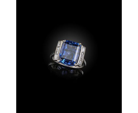 A sapphire and diamond ring, the step-cut sapphire flanked with baguette-shaped diamonds in platinum, size L 1/2 Accompanied 