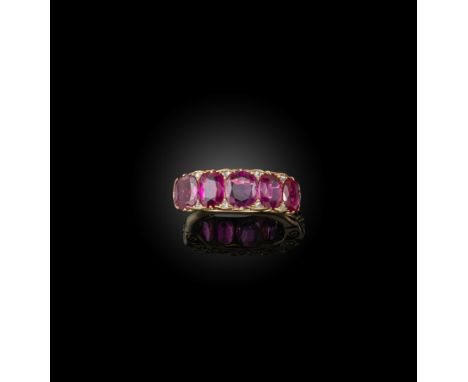 A ruby five stone ring, the five graduated cushion-shaped rubies with diamond pointers in carved yellow gold setting, size L