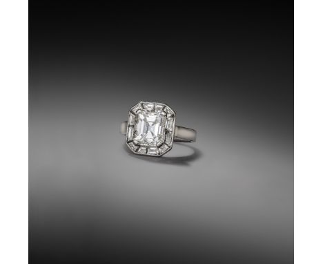 A diamond cluster ring, claw-set with a step-cut diamond weighing 3.01 carats, within a border of channel-set baguette and tr