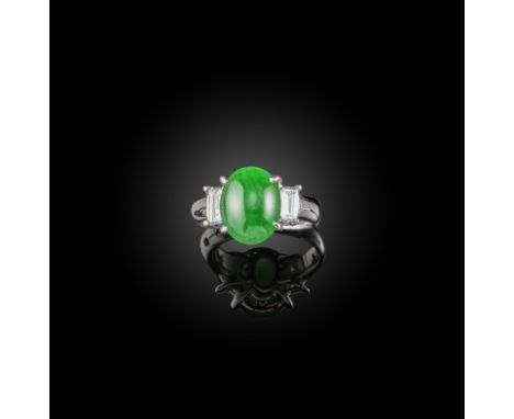 A jade and diamond three stone ring, the oval jade cabochon flanked with baguette-shaped diamonds in white gold, size L