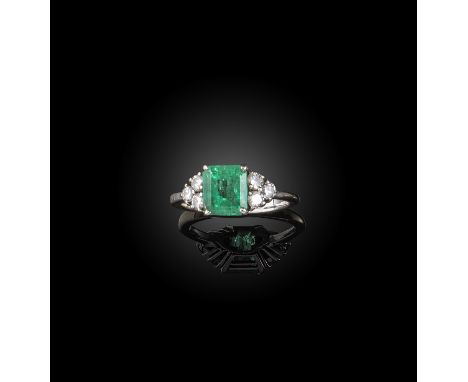 An emerald and diamond ring, claw-set with a step-cut emerald, to shoulders set with trios of brilliant-cut diamonds, mounted