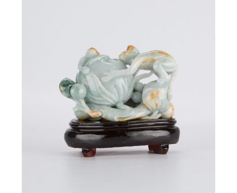 Chinese jade carving of two monkeys surrounding a peach, carved of celadon jade with spinach and russet inclusions. The carvi