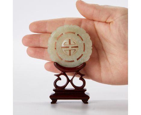 Chinese jade prayer wheel delicately carved with auspicious symbols. With a carved wooden stand.Wheel; diameter 2 1/4 in. Sta