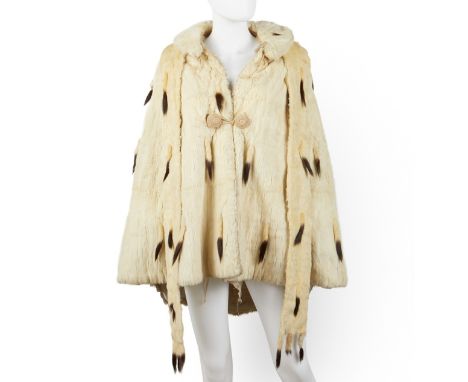 White ermine fur opera cape with a matching belt. With a knit button closure.(Approximate) Cape; Shoulder-to-shoulder: 14 in 