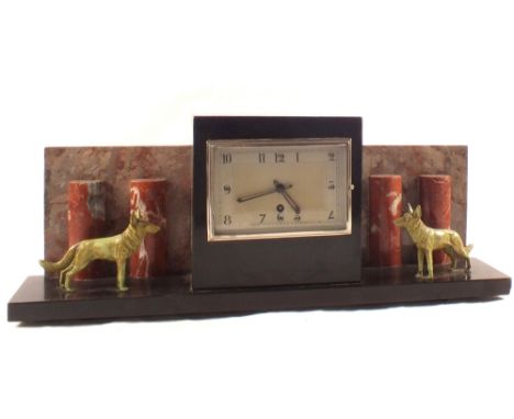 An Art Deco rouge and black marble clock flanked by two spelter dogs