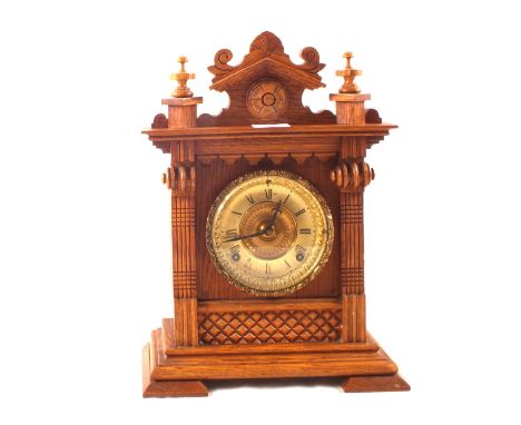 An Ansonia mantel clock in a carved Pine case