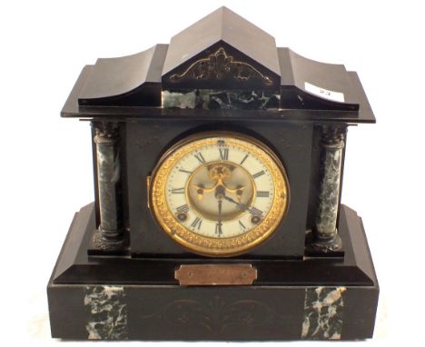 A black slate striking mantel clock