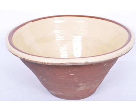 A large Victorian 19th century ceramic mixing bowl being of tapered form with flared rim and having a cream glaze to the inte