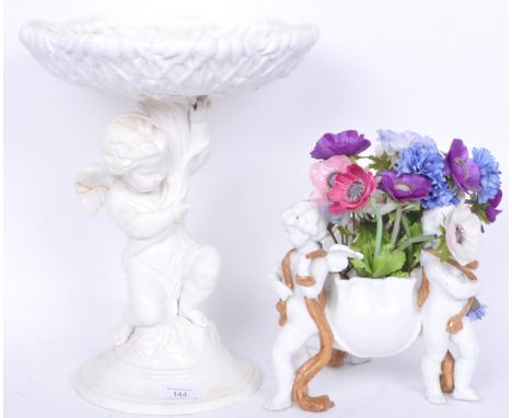 A large 19th century white glazed tall ceramic centrepiece having circular base with large cherub / putti column holding a sh