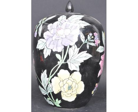 A large vintage 20th century Chinese Famille Noir vase having a finial lid over over a polychrome vase with foliate decoratio