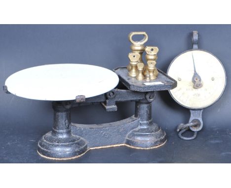 A set of vintage early 20th Century cast iron shop weighing scales finished in black with white ceramic tray atop and set of 