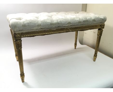 A 19th Century Louis XVI style gilt on carved wood stool with button upholstered seat, approximately 86cm long x 46cm deep x 