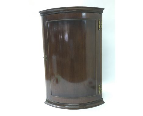 A mahogany corner cabinet with single shelf and locking door, approximately 64cm tall.