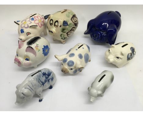 A collection of 8 ceramic piggy banks.