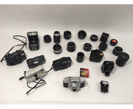 A mix of SLR film lenses, teleconverters, a Canon wireless receiver and various instamatic film cameras, plus an Agfa Rapid f