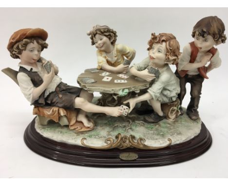 A Giuseppe Armani of Florence Capodimonte figure group of four boys playing cards.