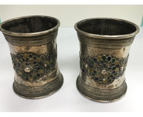 A pair of Middle Eastern white metal and enamel slave bangles with applied roundels