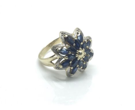 A large 14ct yellow gold ring inset with marquise cut sapphire and diamonds in the form of a flower, total weight approximate