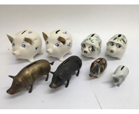 A collection of 6 ceramic and 2 metal piggy banks.