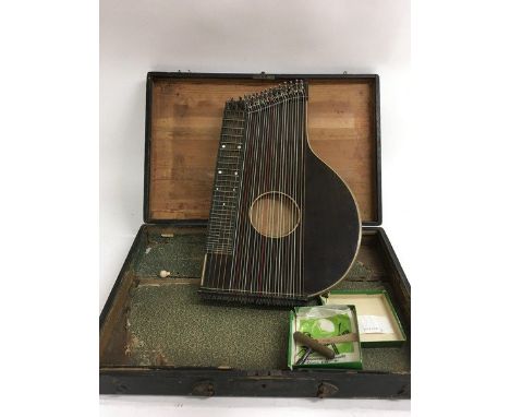 A cased zither with tools and spare string.