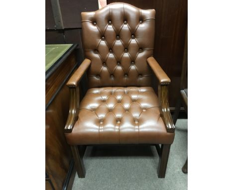 A button back brown leather armchair.