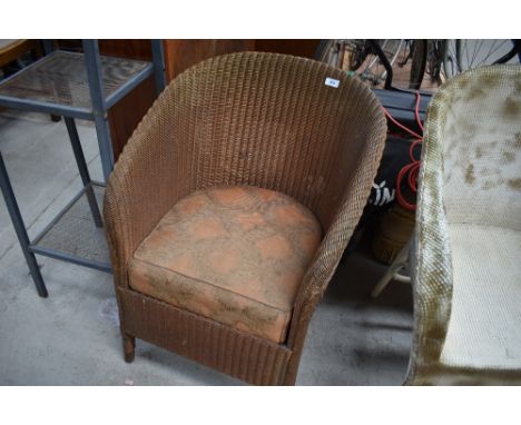 A vintage Lloyd Loom tub chair with upholstered seat