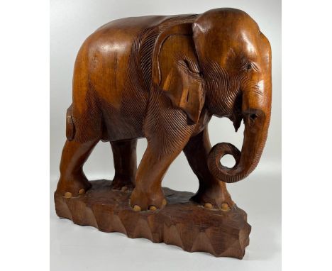 A LARGE AND HEAVY VINTAGE CARVED SOLID TEAK ELEPHANT MODEL, LIKELY CARVED FROM ONE PIECE OF TEAK WOOD, WEIGHS 5KG+, HEIGHT 33