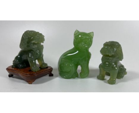 THREE JADE STYLE HARDSTONE ITEMS - PAIR OF CARVED FOO DOGS, ONE ON WOODEN BASE AND A CAT, HEIGHT 7 CM 