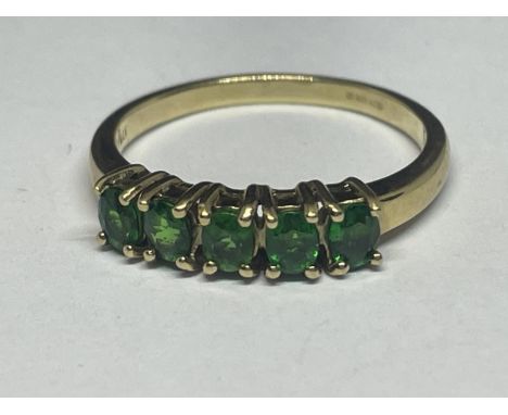 A 9 CARAT GOLD RING WITH FIVE IN LINE EMERALDS SIZE N/0 