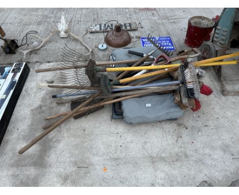 A GARDEN CHAIR AND AN ASSORTMENT OF GARDEN TOOLS TO INCLUDE RAKES AND SPADES ETC 