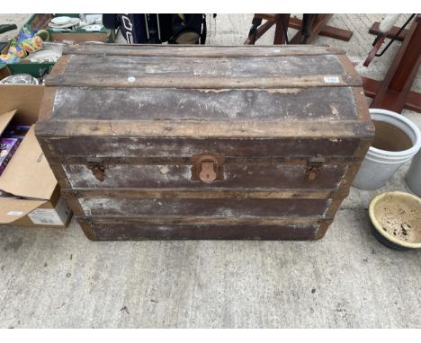 A VINTAGE DOMED TRAVEL TRUNK WITH METAL BANDING 