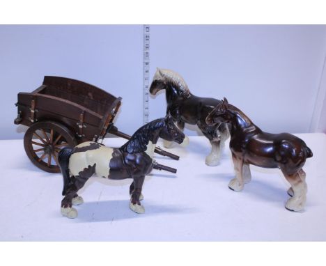 Two ceramic shire horses and a heavy cast iron shire horse with cart 