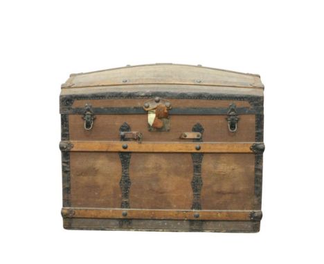the arched top trunk wth timber strapping flanked to each side by carry handles, the top opening to reveal an unlined interio